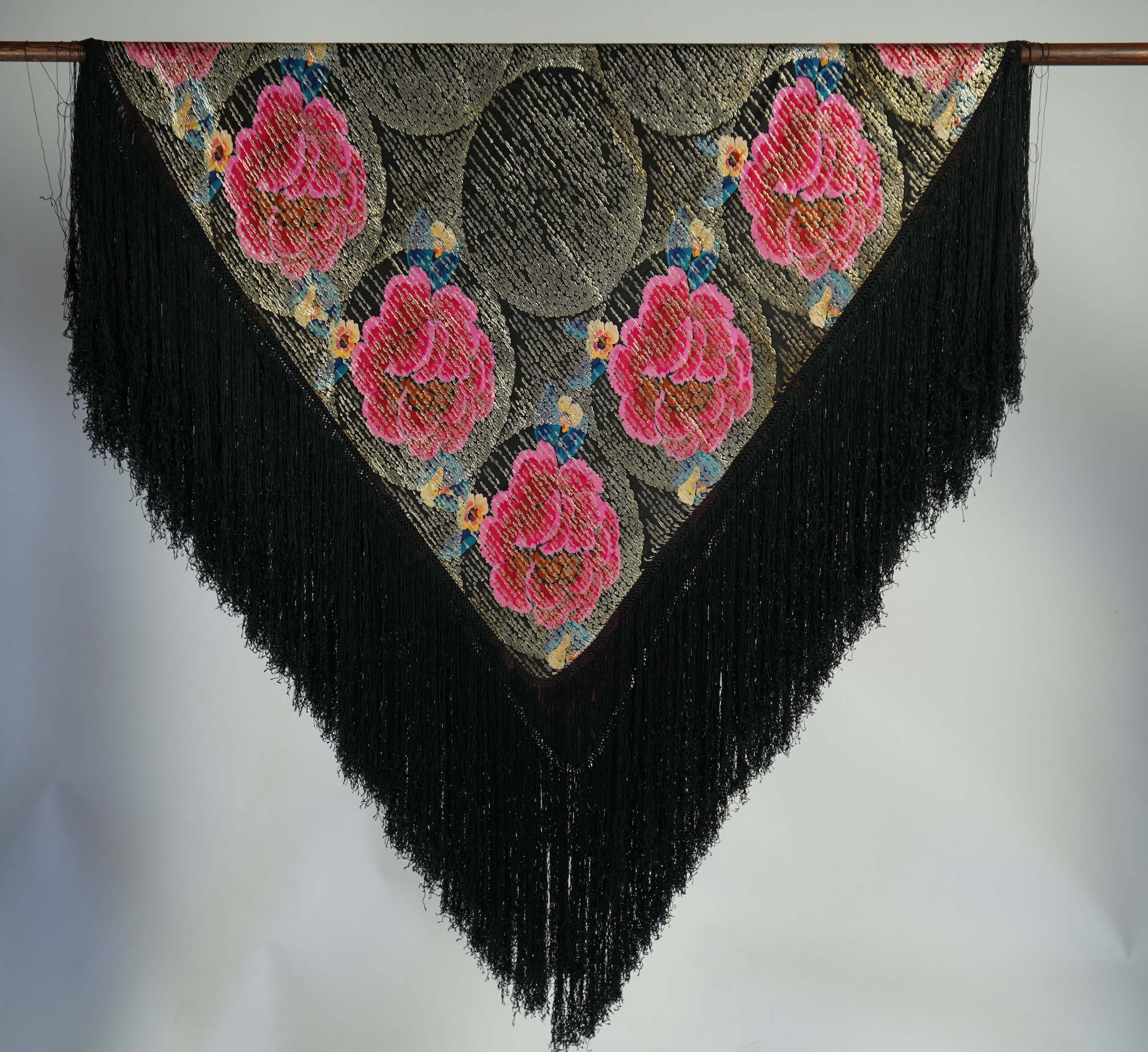 A 1930's ‘jazz age’ black and coloured silk lame evening shawl. Woven with giant pink and red roses and silver thread stripes, edged with long silk fringing. 118cm x 123cm. Condition - colours and silk strong. Fringing g